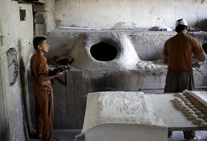 یک پسر کرد برای دفاع از نانوایی خود سلاح در دست گرفته است