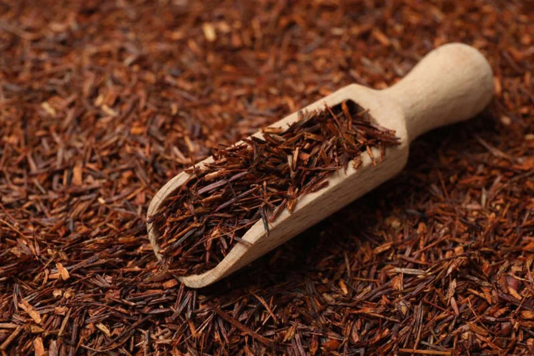 برگ‌های خشک چای سیاه در یک پیمانه چوبی کوچک