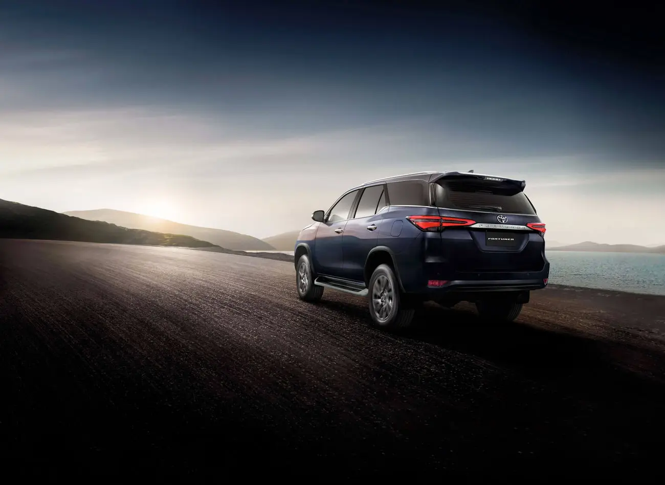 تویوتا فورچونر (Toyota Fortuner) آبی رنگ در جادهای ساحلی هنگام غروب