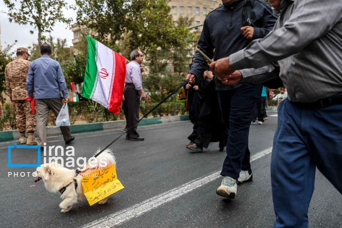 تصاویر رزمایش «جان‌فدایان» در کرج؛ از حضور عروس‌ها و دامادها تا شعارنویسی روی کاغذ و نصب آن بر روی سگ؛ نتانیاهو مثل همین سگ به قلاده می‌کشیمت!